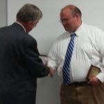 Bartholomew County Commissioners President Carl Lienhoop presents an award to Dispatcher Tony McClain Monday.